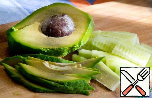 Meanwhile, peel the cucumber and avocado and cut into strips.
