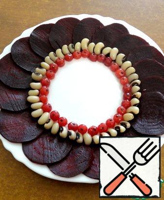 Bake the beets clean, cut into thin circles. Put the beets in a circle in a small dish.
Slightly below beet - boiled beans, then berries.