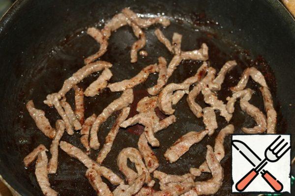 Cut the meat into thin, thin strips and fry over high heat with the addition of sunflower oil.
