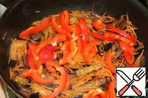 When the carrots are slightly fried, add finely chopped pepper. And all together we fry a little.
