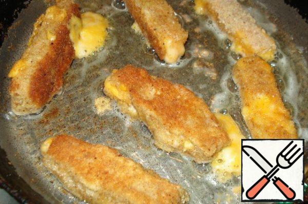 Now here's what we do: roll the cheese slices in the egg, then in the breadcrumbs, then again in the egg and again in the breadcrumbs. And so 3 times, can be 4. Fry in vegetable oil until Golden brown.
