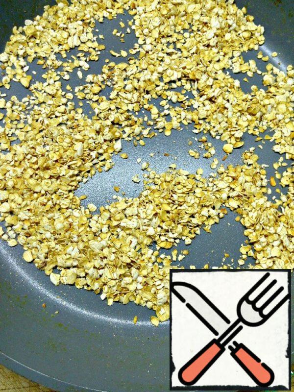 Fry oat flakes on a dry pan for 1-2 minutes, stirring until Golden brown.