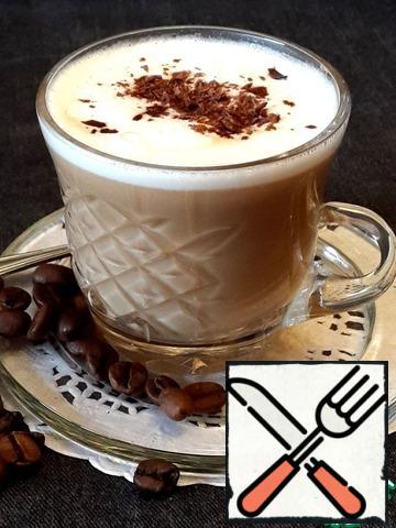In a Cup of milk and liqueur and pour gently the coffee. The rest of the milk, again mix well and spoon gently place the milk foam on top of the drink. Sprinkle with chocolate.