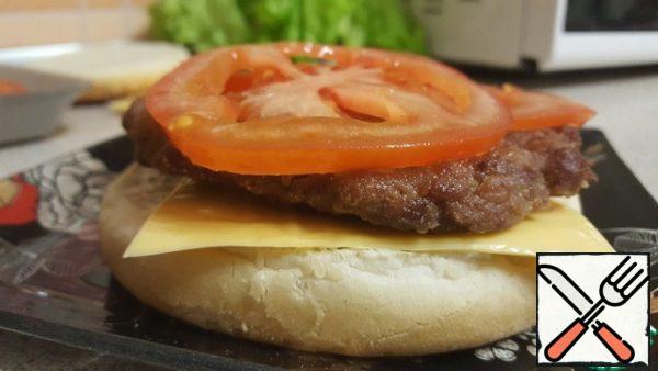 Next, put 2 slices of cheese, patty, tomato 3 rings.