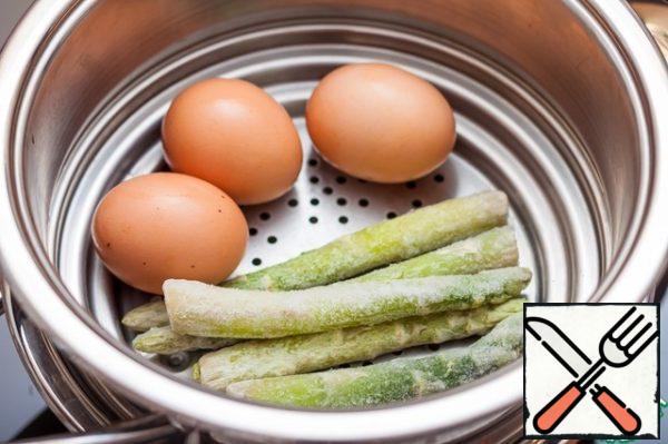 Put a steamer in a saucepan, put the eggs, which should be pre-washed with soap and water. I also decided to cook asparagus, which I later served with ready-made hummus as another snack. Sprinkle the asparagus with a small amount of lemon juice.
