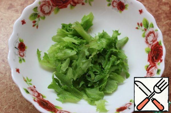Put the lettuce leaves in a bowl with your hands.
