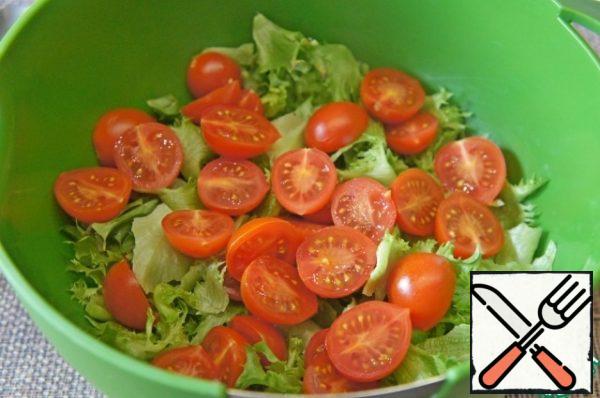 Tear the lettuce leaves with your hands and put them in a deep bowl. Cut cherry tomatoes in half or into quarters, add to the salad.
