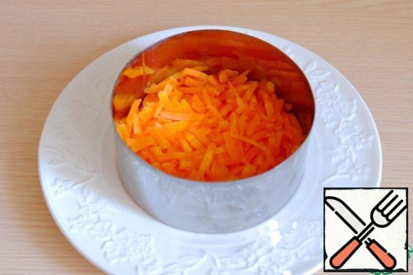 A metal ring was used to decorate the salad. Put a layer of carrot straws on the bottom.
