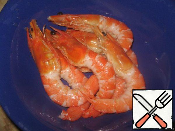 Shrimp defrost, clean from the shell, leaving the head does not tear off (and do not clean), that is, clean only the tails. Just like this. Lightly salt the shrimp.