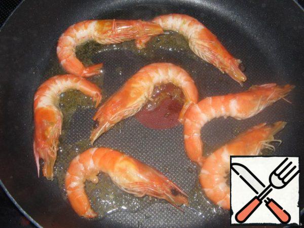 On a well-heated frying pan, pour olive oil (1 tablespoon), and spread the shrimp (without marinade). Fry them.