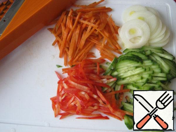 All vegetables, clean and cut: carrots, bell pepper and cucumber - straw, onion - rings. It is convenient to use a grater.