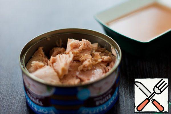 Drain the liquid from canned tuna, break it into pieces with a fork.