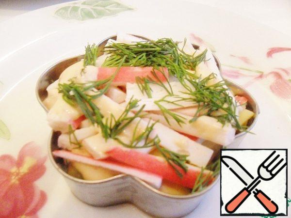 Now spread the crab sticks and lightly grease them with mayonnaise sauce. Sprinkle with chopped dill.