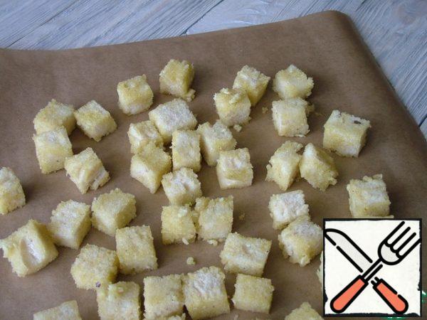 This fragrant oil is well mixed with croutons, put them on a baking sheet.