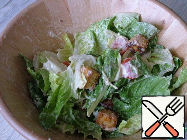 Add tomato halves, croutons, 40 g Parmesan, and sauce, mix.
Spread the salad on plates, around lay out pieces of Turkey and sprinkle with the remaining Parmesan.
