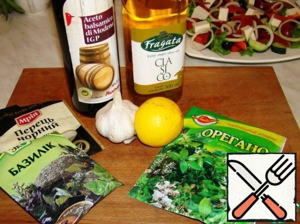We'll prepare the refueling. Mix olive oil with balsamic vinegar and add the juice of half a lemon. Season with salt, pepper, oregano and basil. Add the garlic passed through the press.
