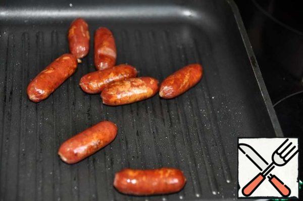 Hunting sausages fry on a grill pan.
I have mini sausages. If you have long sausages, then cut into 3-4 cm.