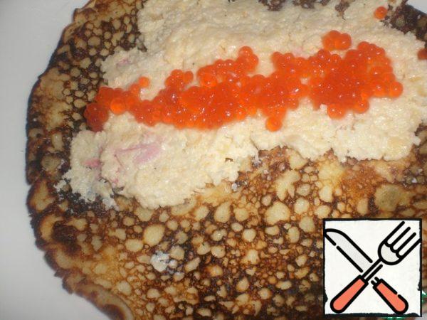 Spread the caviar on top. Roll up the pancake roll, cut across into small rolls and insert a toothpick-you will get canapes