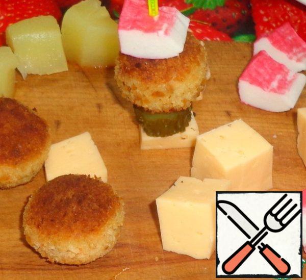 Make canapes, alternate between the ingredients.
For this hard cheese cut into cubes. Pickled cucumber and crab sticks into small pieces.
The finished dish can be served immediately to the table.
Bon appetit!