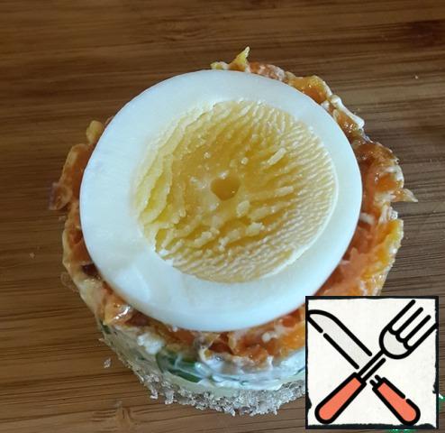 Carrot, brush with sauce is not necessary. Carefully remove the mold from the canapes, put on top of a circle of boiled eggs.