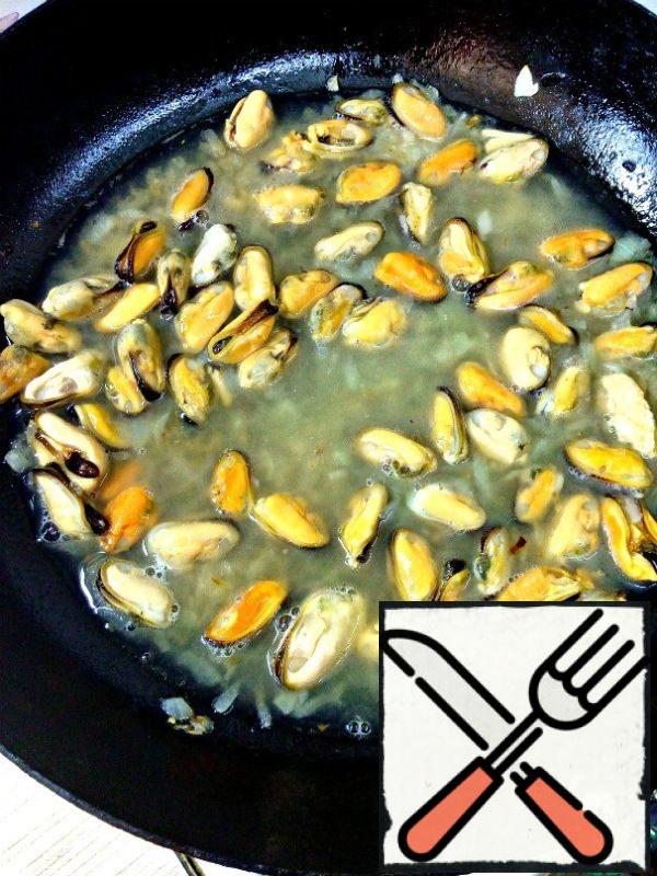 Add mussels to the onion and pour in the wine. Simmer for 8 minutes, then transfer to a plate with a slotted spoon and cool.
