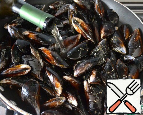 Put the mussels in a large pan and add the dry white wine, put on the fire, cover and let the sinks open!