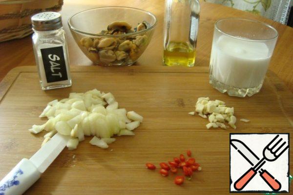 Prepare the food. Peel onions and garlic and chop finely. Red pepper to release the seeds and finely chop. Mussels thawed, place on a paper towel then in a bowl and pour the lemon juice for 15 minutes.