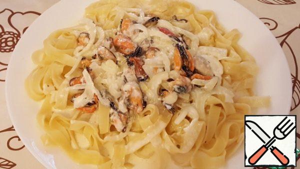 On pasta in the middle of the plate spread with a spoon the mussels with the onions and pour the sauce. The final touch is cheese. Rub on a fine grater cheese and generously sprinkle our dish!!! Bon appetit!!!