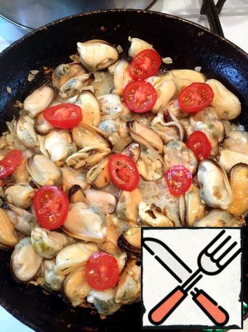 Put the mussels and sliced cherry tomatoes to the fried onion, add salt, season to taste, add lemon juice and fry over high heat.