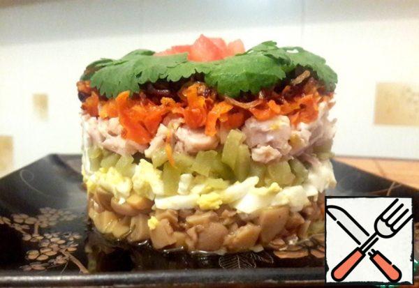 Shape the salad.
1st layer: mushrooms, a bit of mayonnaise
2nd layer: egg
3rd layer: cucumbers, garlic
4th layer: chicken, a little mayonnaise
5-th layer:carrots, and onions.
Top spread a thin layer of mayonnaise and decorate with herbs.
Salad's ready!