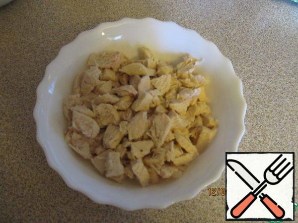 Boil the chicken fillet and cut into cubes.
