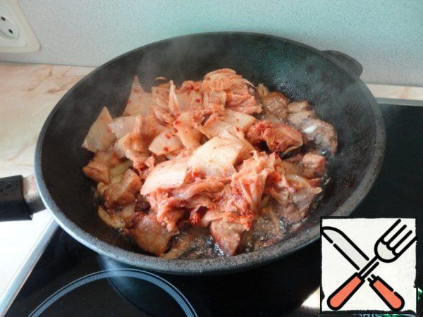 Kimchi cut into medium pieces, put in a frying pan, mix. Take care of your eyes!
