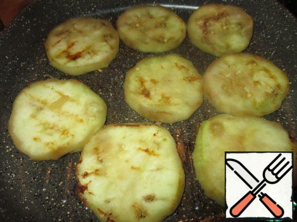 Eggplant wash, peel, cut into slices thickness of about 0.5 cm, salt thoroughly, mash with your hands. Set aside for 20 minutes. Then to rinse, wring out slightly and fry both sides in a little oil until soft.
