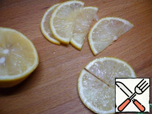 Pour boiling water over the lemon, wipe dry and cut into thin half-rings.