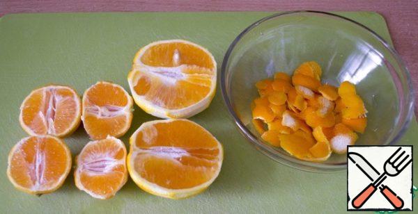 While the mixture is infused, pour boiling water over the oranges and tangerines, rinse well. Remove the zest from both fruits, cut in half.
