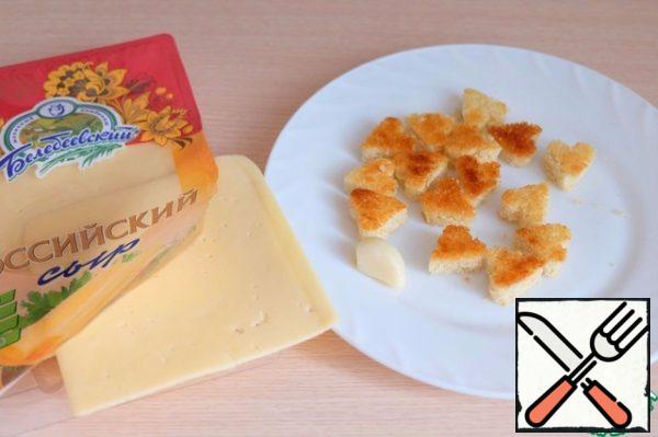 Grate the fried croutons in the shape of hearts with a clove of garlic.
