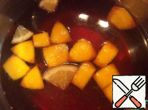Cut the orange into pieces and add to the wine. Heat the mixture over low heat until the first bubbles appear, cover and let stand for about 10 minutes.