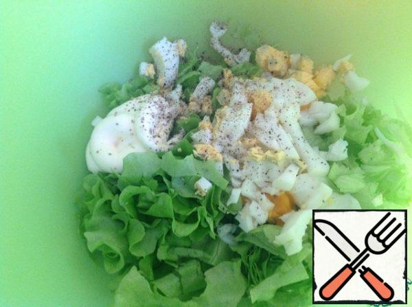 Chop the lettuce. Add mayonnaise and ground pepper. Eggs cut into cubes.