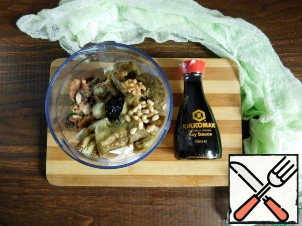 Put the baked eggplant pulp, cheese, parsley, peeled garlic, two types of nuts in the blender bowl (leave some cedar nuts to decorate the dishes). Grind everything to the desired consistency. Add 2 tablespoons of vegetable oil, soy sauce and lemon juice. Season with black pepper and whisk again in a blender.
