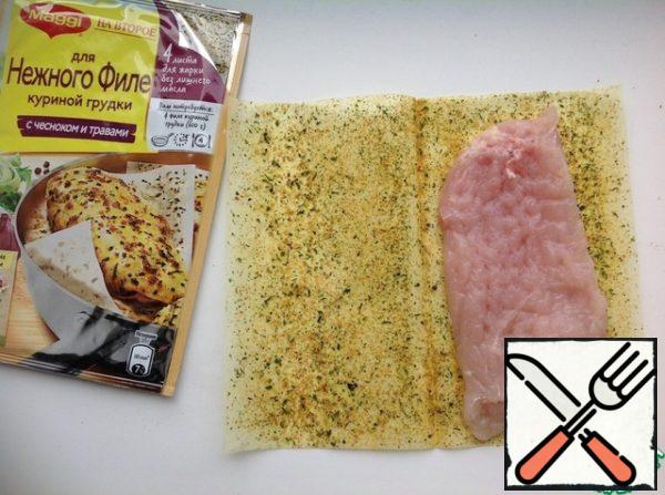 Wash the chicken breasts, dry them and beat them off with a hammer to a thickness of 1.5 cm. The sheet for cooking "for tender chicken breast fillet with garlic and herbs" is unwrapped, put on one half of the chicken, cover with the second half of the sheet. Press down with the palm of your hand.

