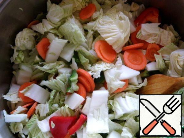 Peel, wash and dry the vegetables. Cabbage cut into large pieces, carrots cut into slices, pepper -petals. Garlic is also cut into slices and add 15 minutes before cooking, so that it activates the nutrients better.
