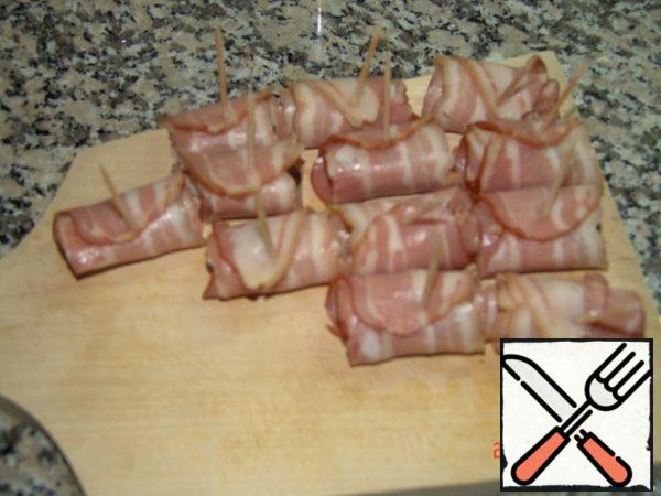 Each date is wrapped in a strip of bacon, fasten with a toothpick, placed on a baking sheet. When all dates are wrapped, then, if desired, on top of the canapes can be applied a few drops of honey. Put in the oven for 5, maximum 10 minutes. It can be served hot or warm in combination with chilled white wine or champagne. Bon appetit!