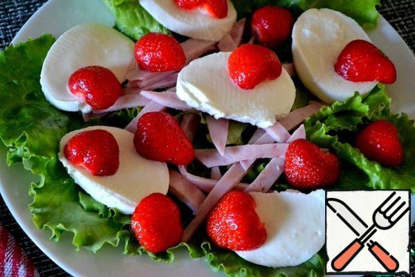 Put sliced mozzarella and halves of strawberries over the ham.
Try for the first time a small portion of berries.
We are lovers of strawberries in salads. Feel free to put it a lot.