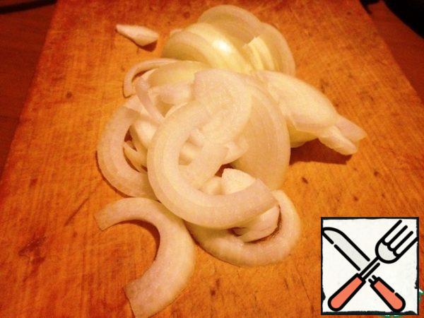 Peeled onions, cut into half rings. Add to saucepan. Stir.