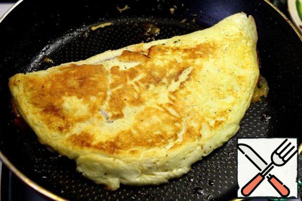Cover and fry for a couple of minutes. Roll the omelet in half, fry until Golden brown and serve, sprinkled with Parmesan.