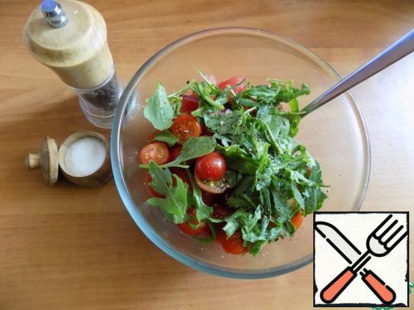 Small arugula leaves, leave whole, tear large smaller. Cut cherry tomatoes in half. All send in salad bowl. Stir and doselevel if it seemed a little salt and pepper as desired.