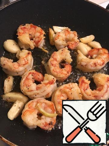 Mix in a frying pan vegetable oil + a small piece of cream, add garlic, heat all to the characteristic pleasant garlic smells and add the shrimp. Fry for a couple of minutes on each side. Take it out and lay off until aside.