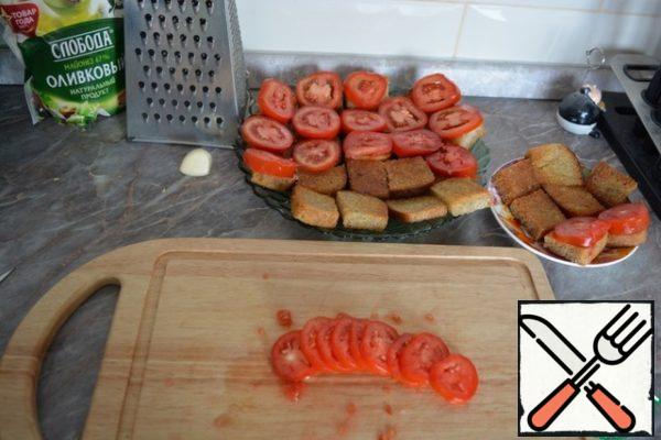 Cut the tomatoes into slices and put on top of the bread.