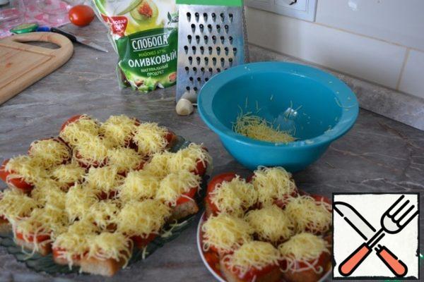Grate the cheese on a small grater and sprinkle on top of tomatoes.