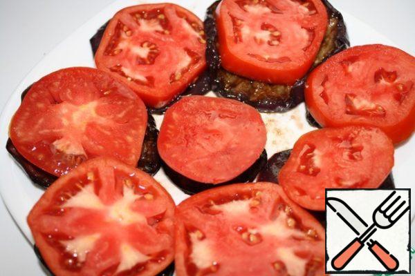 Place the eggplant on a plate or directly on the pieces of bread.
Slice the tomato on the washer and put in on a slice of eggplant.